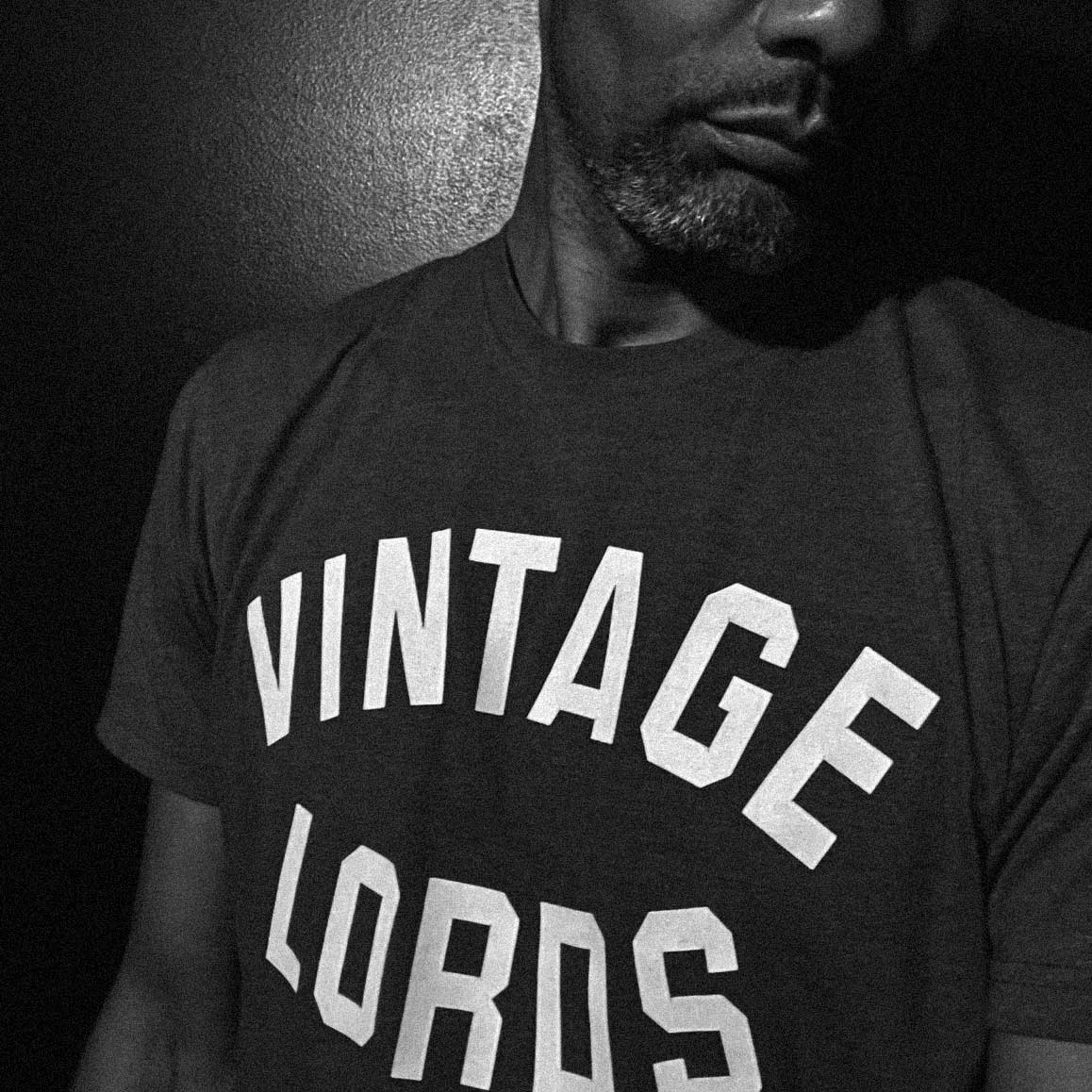 Man wearing dark t-shirt with Vintage Lords name on chest